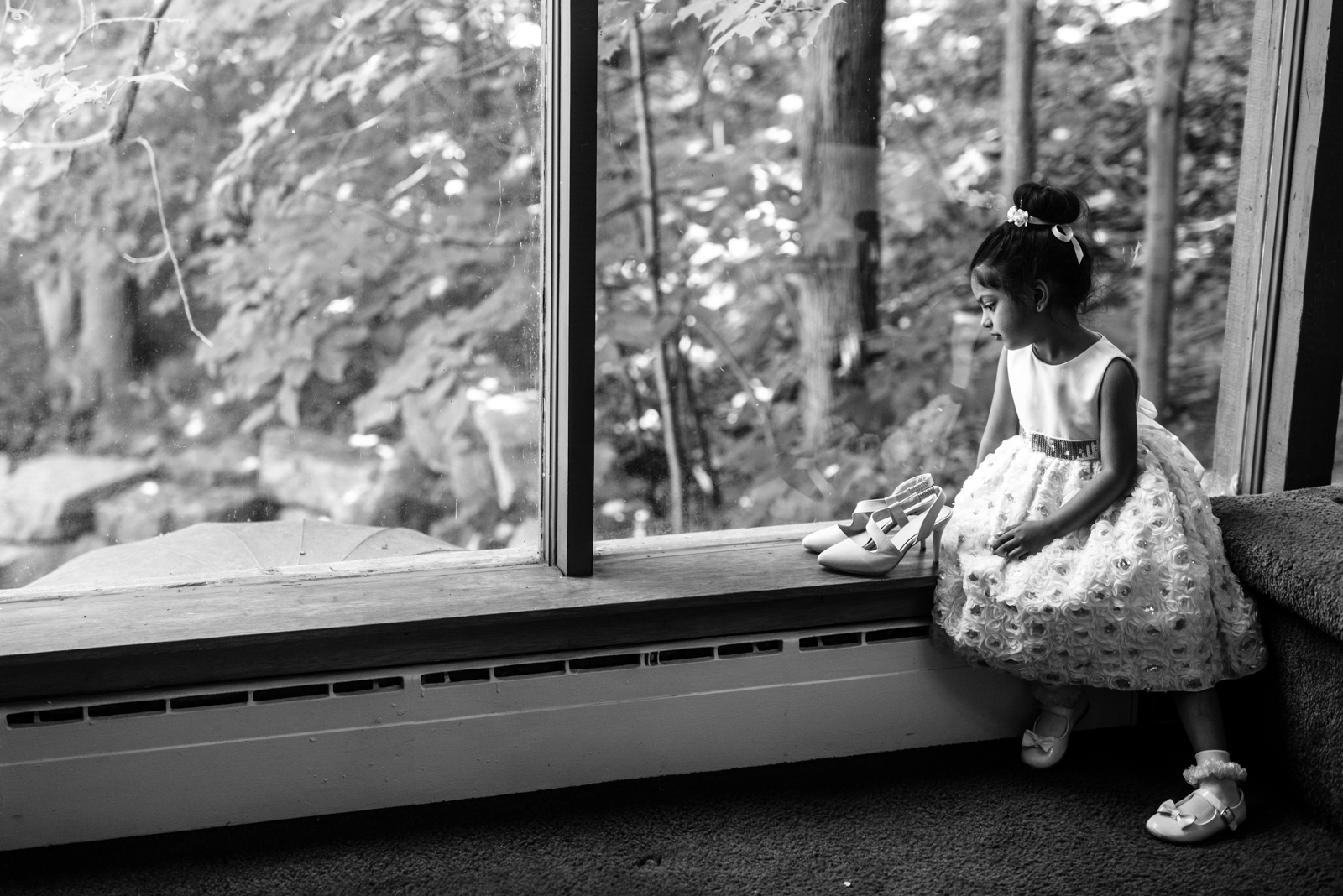 the flower girl is watching the bride shoes