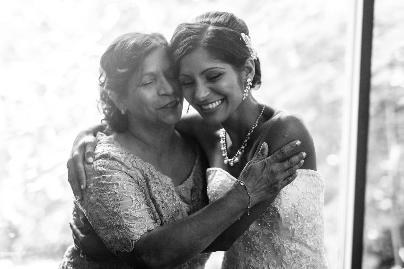 the bride is hugging her mom in the morning