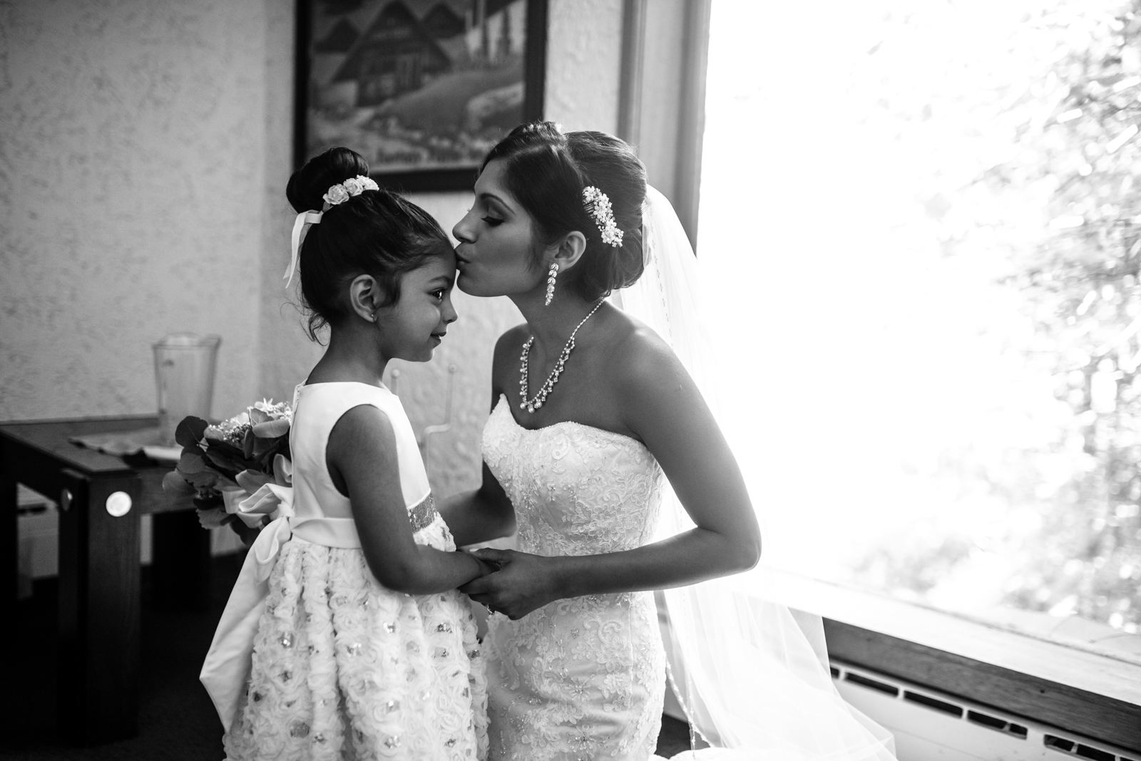 the bride is kissing the flower girl