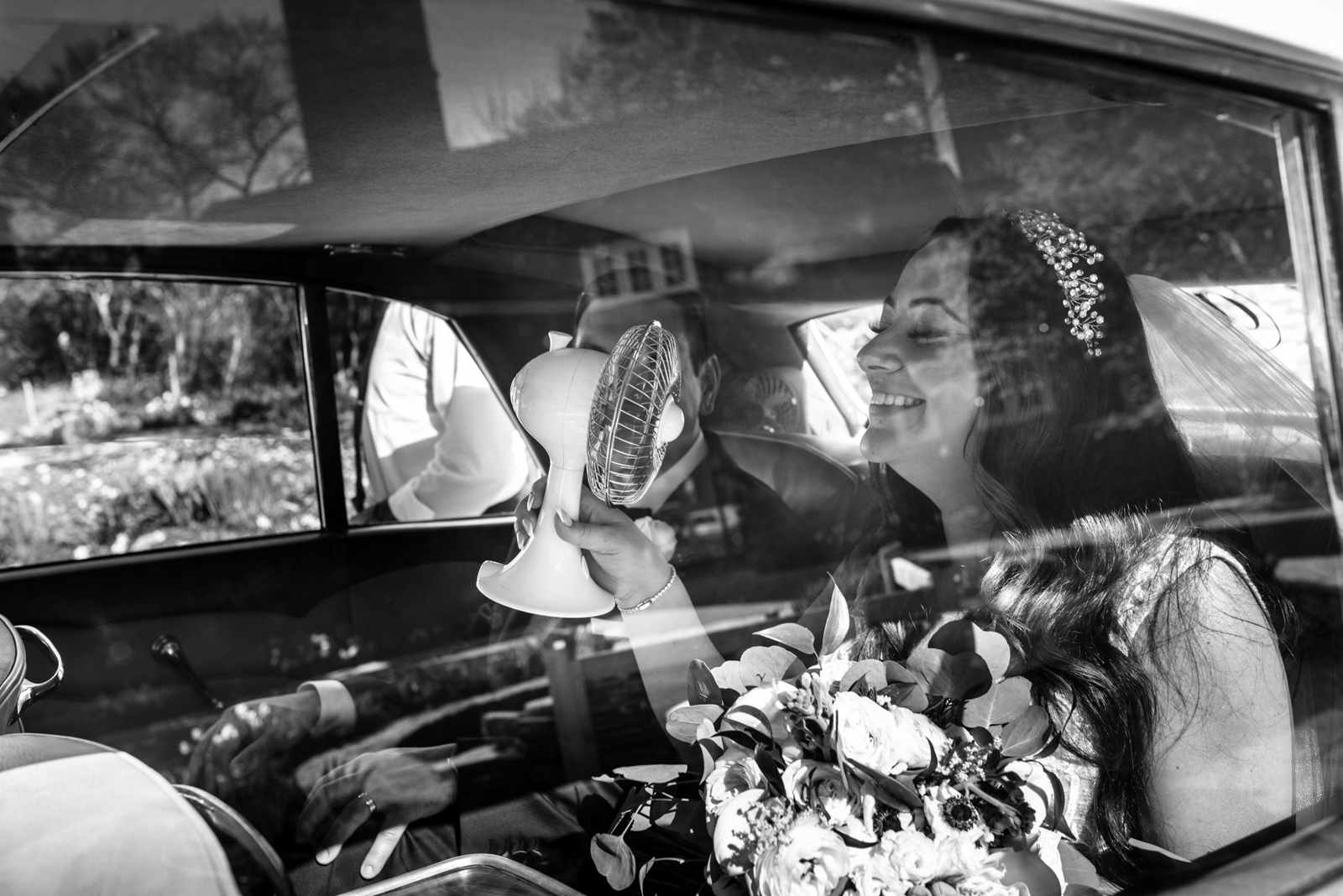 the bride is using the mini fan to cool her down in the hot car