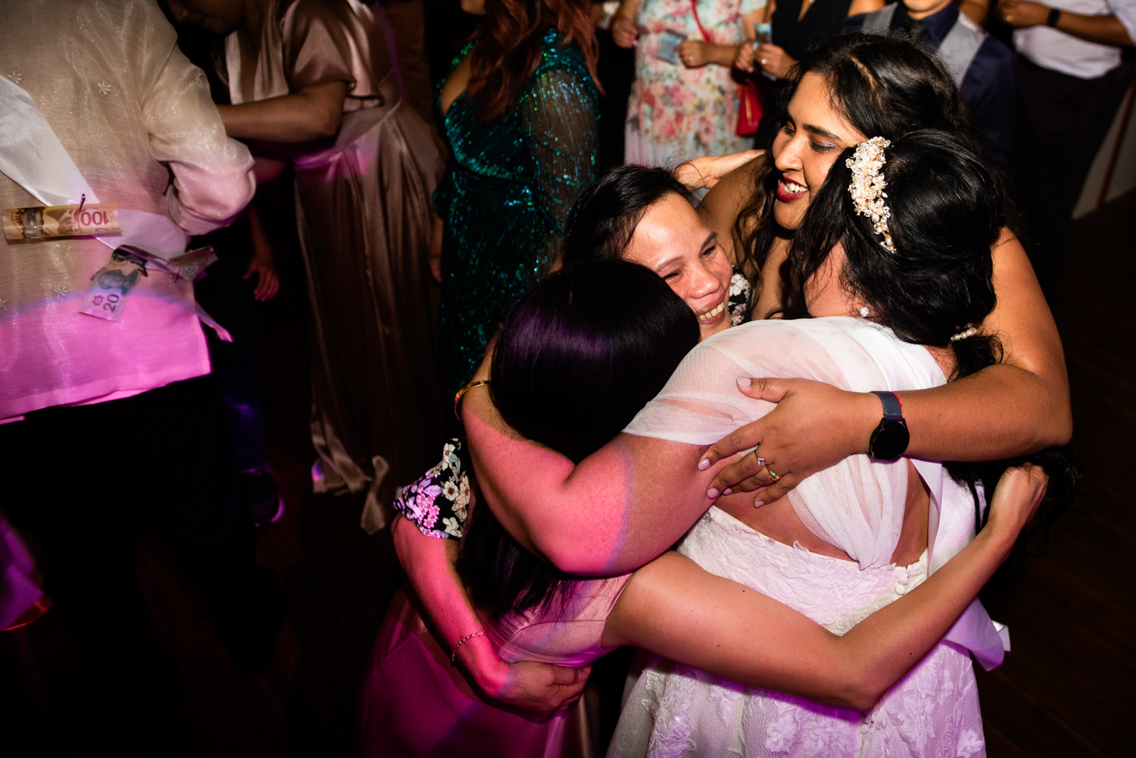the bride is hugging her friends on the wedding dancing floor