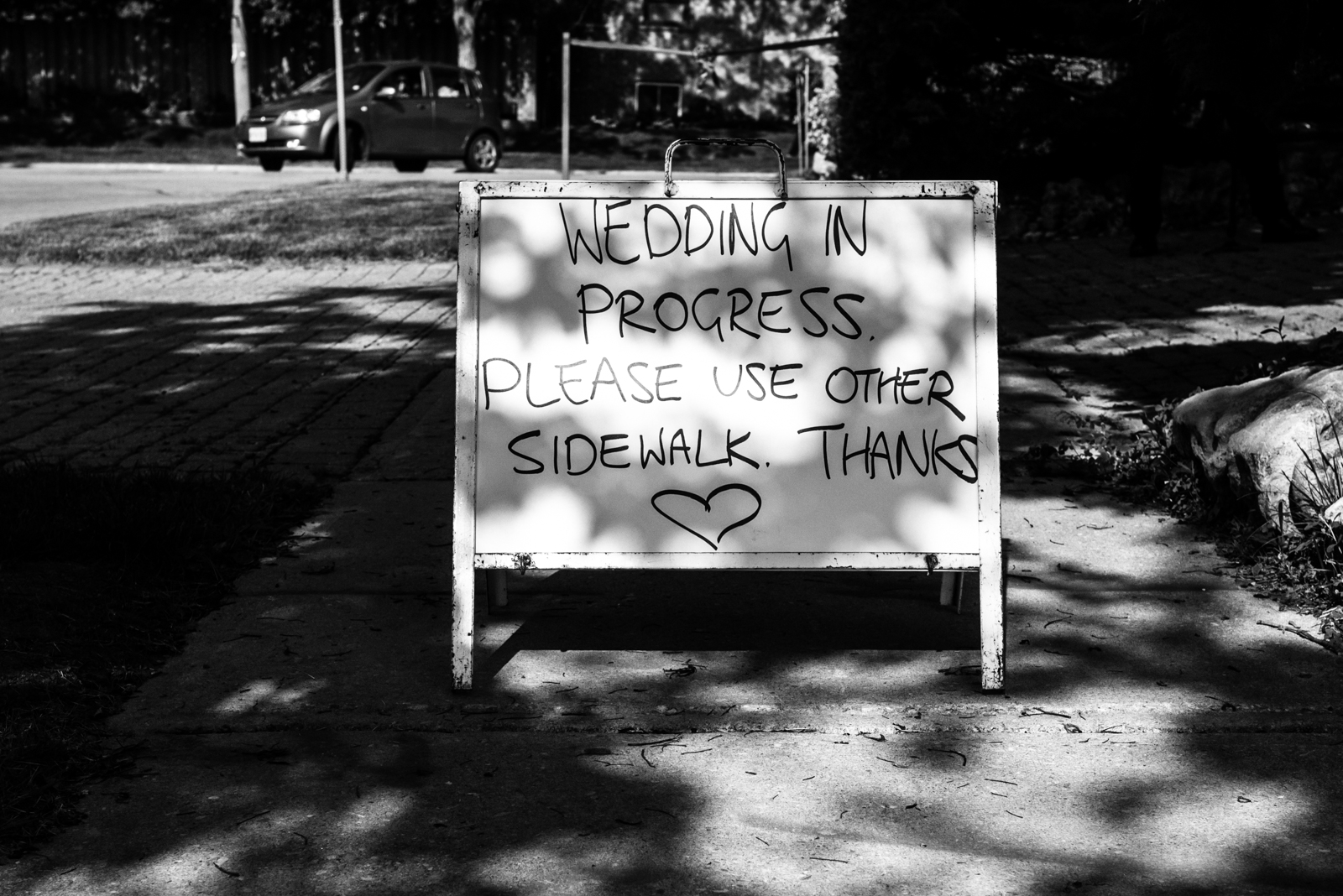 the sign on the road which said "wedding in progress please use other sidewalk"