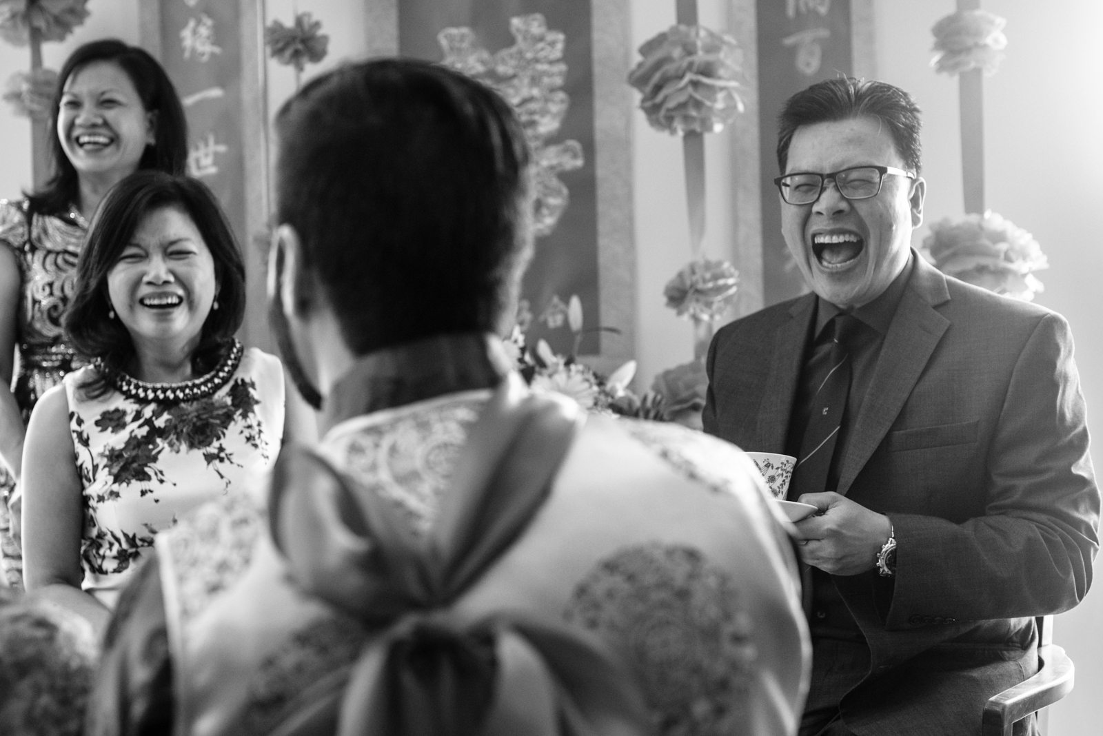 candid capture of people laughing at tea ceremony on Chinese Wedding taken by documentary wedding photographer cafa liu
