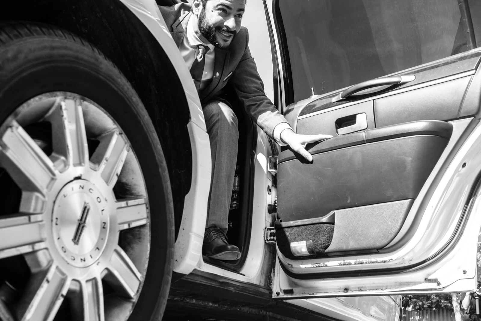 candid moment of groom step out of limo